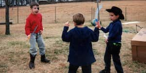 Jona sword-fights with some friends in the yard.