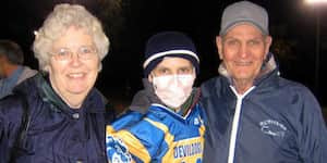 Jona holding a football with his grandparents.